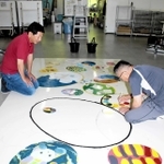 壁画の制作を見守る谷口文保さん（左）＝神戸芸術工科大学