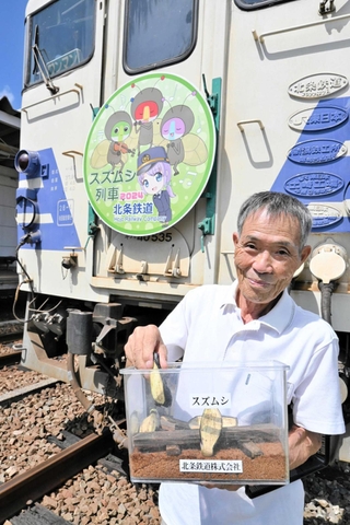 キハ４０形に取り付けられたスズムシ列車のヘッドマークと小林桂さん＝北条鉄道北条町駅