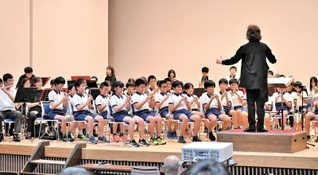 西本智実さんの指揮でアフリカンシンフォニーを演奏する九会小学校児童ら＝加西市民会館