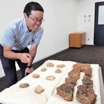 浄土寺境内から出土した炉壁や鋳型の破片を示す山本原也学芸員＝小野市役所