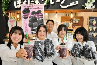 育てたブドウとスムージーを手にする播磨農高の生徒たち＝アスティアかさい