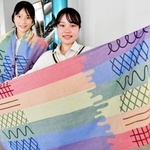 ６色のレインボーフラッグにちなんだストールをデザインした徳平さん（右）と、ともに会議に出席する長谷川さん＝西脇高校