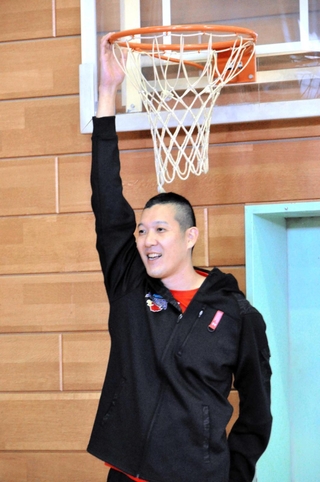バスケットボールのリングをつかんで見せる山村宏太さん＝下東条小学校