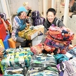 残布を巻き付け、カラフルな色合いに仕上げた「オリアイ（織り合い）」の作品とアユミアダチさん（左）、玉木新雌さん＝西脇市比延町