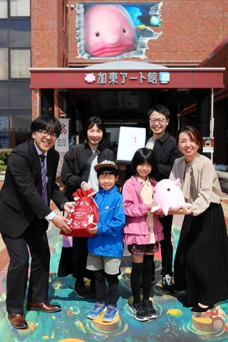 ３万人目の来館者として記念品を受け取る瀧井さん家族＝加東市下滝野