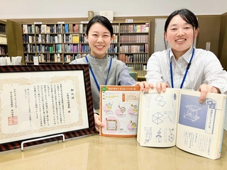 四角いシャボン玉が載った本を持つ東後江里奈さん（右）と司書の中村一香さん＝小野市立図書館