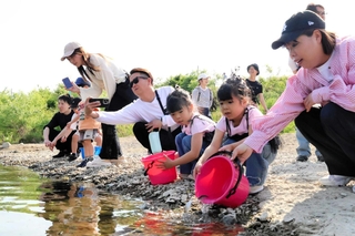 バケツから稚アユを放流する子どもら＝加東市上滝野