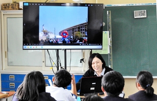 視察した大阪・関西万博会場を６年生に説明する北山佳奈教諭＝中番小学校