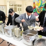 提供された昼食を皿に盛り付け、笑顔を見せる生徒＝多可高校