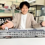 制作を手がけた黒田正憲さん。スマートフォンでＱＲコードを読み取ると、画面上に福田小学校の校舎がＡＲで現れる＝加東市社