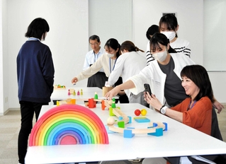 木のおもちゃを使い、動画を撮影する小野市職員有志＝同市役所