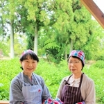 テラス席で新調したエプロンなどを身に着ける柳田みどりさん（右）ら喫茶店の運営メンバー＝ＴＵＭＡこいカフェ