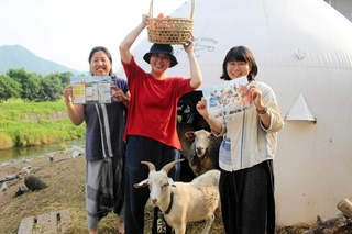 野菜と催しのチラシを手にするタマキニイメのスタッフら。飼育する動物たちも登場＝西脇市比延町