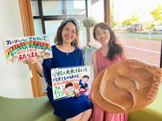 親友が書いてくれた歌詞やイラストを手にする熊木ルミさん（左）とライアーを持つ姉の石田エリさん＝小野市役所