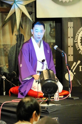 昨年の怪談会で青白い照明を浴びながら話した城谷歩さん＝神戸市中央区東川崎町１