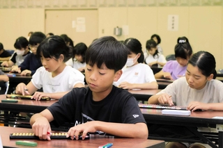 競技大会でそろばんをはじく子どもたち＝小野市伝統産業会館