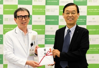 西村善博病院長（左）に目録を手渡すブレインの神戸壽会長＝北播磨総合医療センター
