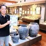 作成途中の計画の概要版を手にする安平勝利さん。館内には多可町の文化財が並ぶ＝那珂ふれあい館