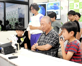 国際宇宙ステーションと交信する子ども（右手前）ら＝多可町役場