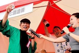 蔵元のブースで日本酒を堪能する吉田類さん（左）＝加東市社