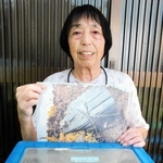 スズムシの写真を持つ藤本緑さん＝多可町