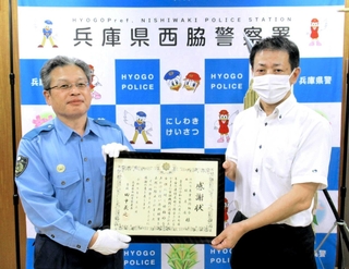 田中義之署長（左）から感謝状を受け取る西川健太郎支店長＝西脇署