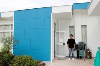 お試し移住などで使われる旧水尾町公民館の前に立つ佐藤敬生さん＝西脇市水尾町