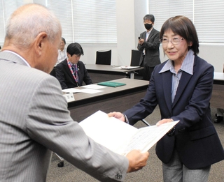 西脇市議選の当選証書を受け取る長谷川智春氏（右）＝西脇市役所