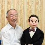相棒の腹話術人形「シンちゃん」とともに笑顔を見せる腹話術師の春風小イチローさん＝加西市下宮木町