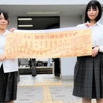 ＪＲ加古川線の中づり広告をデザインした西脇高校の大野愛華さん（左）と笹倉彩愛さん＝西脇市野村町（北播磨県民局提供）