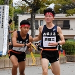 男子・西脇工の６区林恭大選手（右）が、７区岸本周真選手にたすきをつなぐ＝西脇市西脇、市総合市民センター