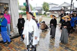 白い羽織姿で大名役を務めた田中浩温さんら一行＝小野商店街