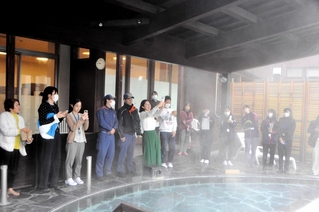 大浴場でスマートフォンによる撮影のこつを学ぶ参加者たち＝白雲谷温泉ゆぴか