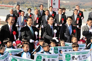 テープカット後、市場こども園の園児らと記念撮影する出席者＝小野市池尻町