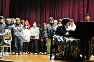 舞台に上がって牧村英里子さん（手前右）の演奏を聴く生徒たち＝小野工業高校