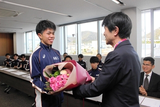 片山象三市長（右）から花束を受け取る西脇工業高校男子陸上部の新妻昂己主将＝西脇市役所