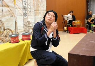 学生服を着て主役の女性従業員を熱演する高城力也さん＝多可町八千代区中野間