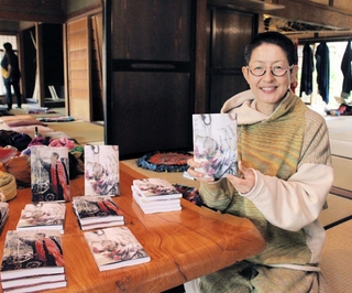 著書を手にする玉木新雌さん＝西脇市嶋