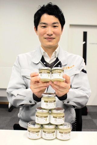 ソースを手にする足立醸造の足立学さん＝多可町中区茂利、同町商工会館