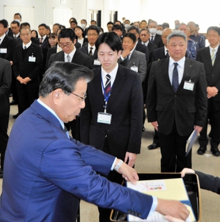 蓬萊務市長（手前）から最優秀提案の表彰を受ける福岡諒大さん（中央）＝小野市役所