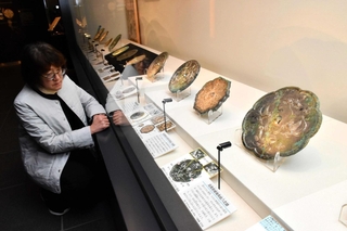 鳳凰の文様がある古代中国鏡が並ぶ＝古代鏡展示館