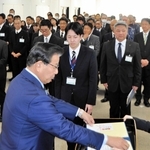 蓬萊務市長（手前）から最優秀提案の表彰を受ける福岡諒大さん（中央）＝小野市役所