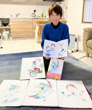 原画を前に絵本を持つ森脇千丹さん＝小野市復井町