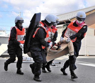 災害救助訓練で要救助者を運ぶ女性警察官＝小野署