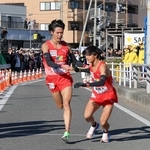 箱根駅伝で好走した城西大の７区山中達貴選手（左）から８区小田伊織選手への西脇工高ＯＢリレー＝１月３日、神奈川県平塚市の平塚中継所