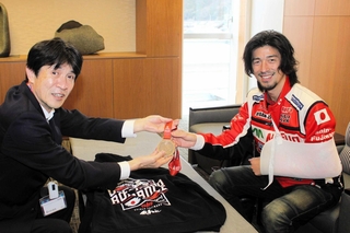 片山象三市長（左）に完走者メダルを見せる藤原慎也さん。鎖骨骨折のため左腕を固定している＝西脇市役所