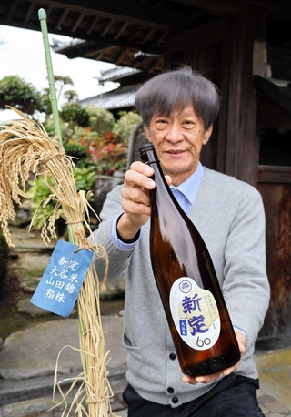 「新定」を手に取る山田錦語り部の平川嘉一郎さん＝加東市新定