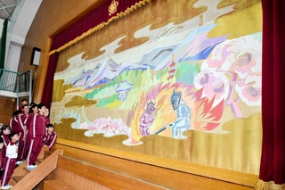 小篠綾子さんが寄贈した緞帳。西在田小学校区の自然豊かな風景が描かれている＝同校