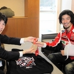 片山象三市長（左）に完走者メダルを見せる藤原慎也さん。鎖骨骨折のため左腕を固定している＝西脇市役所