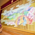 小篠綾子さんが寄贈した緞帳。西在田小学校区の自然豊かな風景が描かれている＝同校